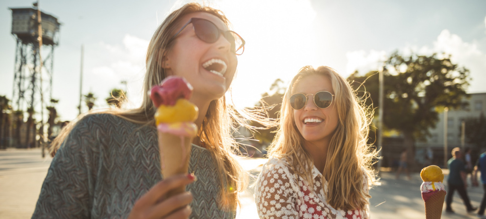 Zwei Freundinnen essen Eis und lachen